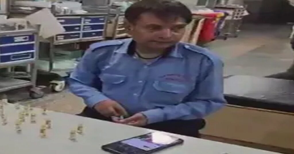 Security guard filling medicine into a syringe at Noida District Hospital